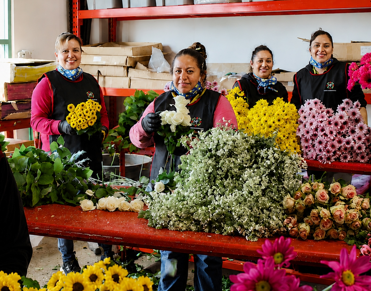 Staff at Maciel’s Flowers preparing and displaying fresh flowers, including roses and chrysanthemums.
