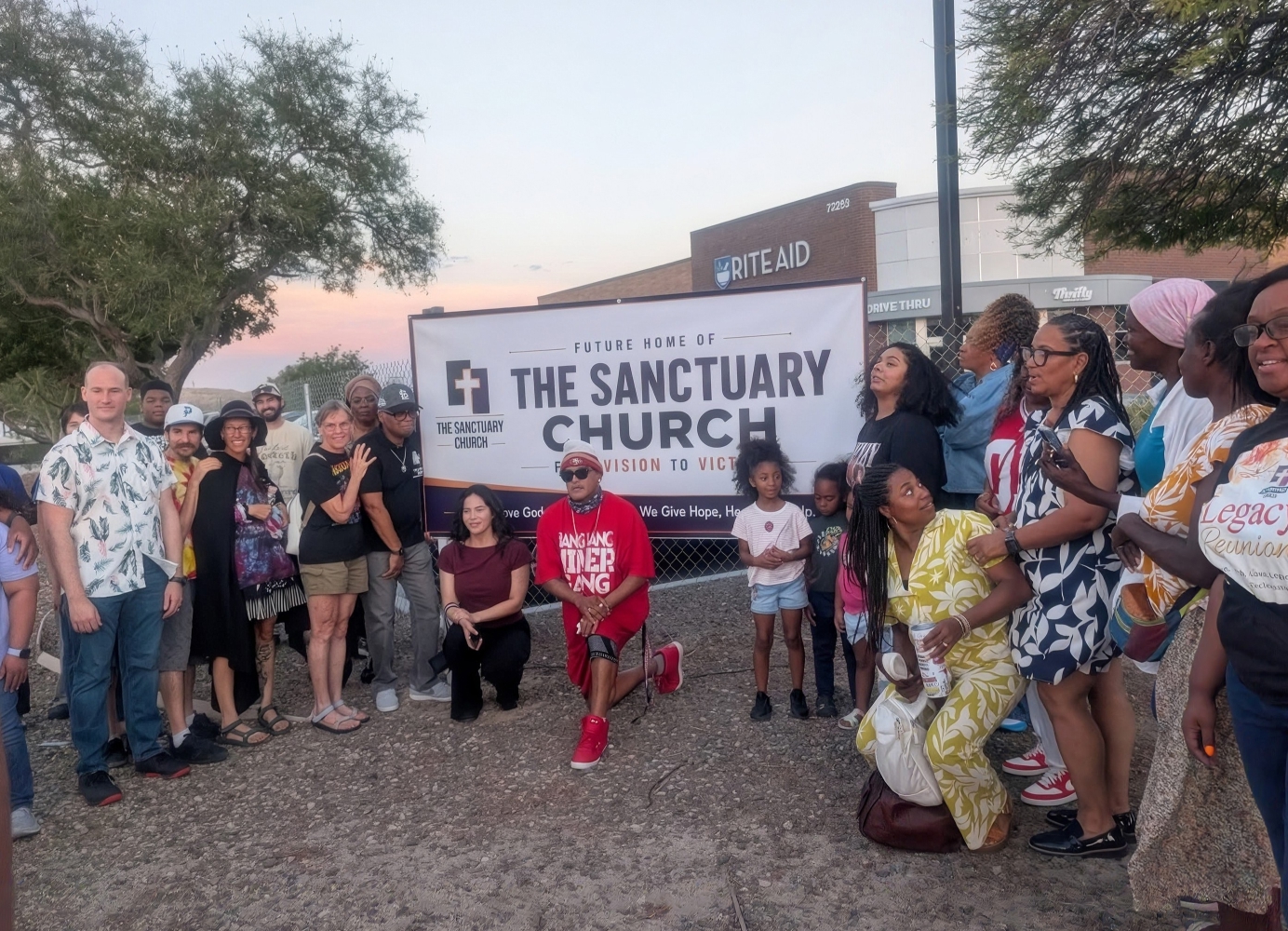 Members of The Sanctuary Church gathered around a sign marking the future home of the church.